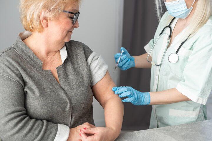 Señora mayor vacunándose de la gripe