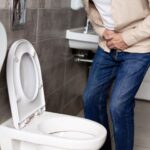 Anciano con problemas urinarios en el baño de su casa