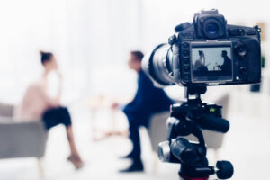 Primer plano de una cámara la cuál está grabando una entrevista de trabajo