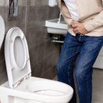 Anciano con problemas urinarios en el baño de su casa