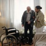 anciano con demencia acompañado por su cuidadora en su casa