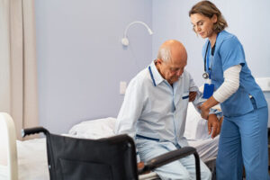 Cuidadora ayudando a levantar a un anciano de la cama