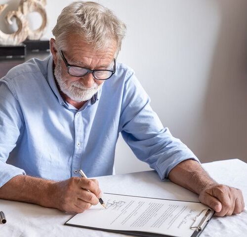 Persona mayor firmando poder notarial