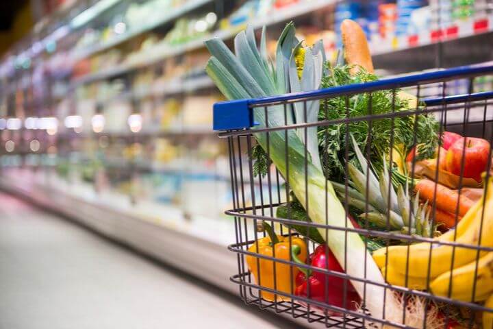 Carro de compra con frutas y verduras en el supermercado